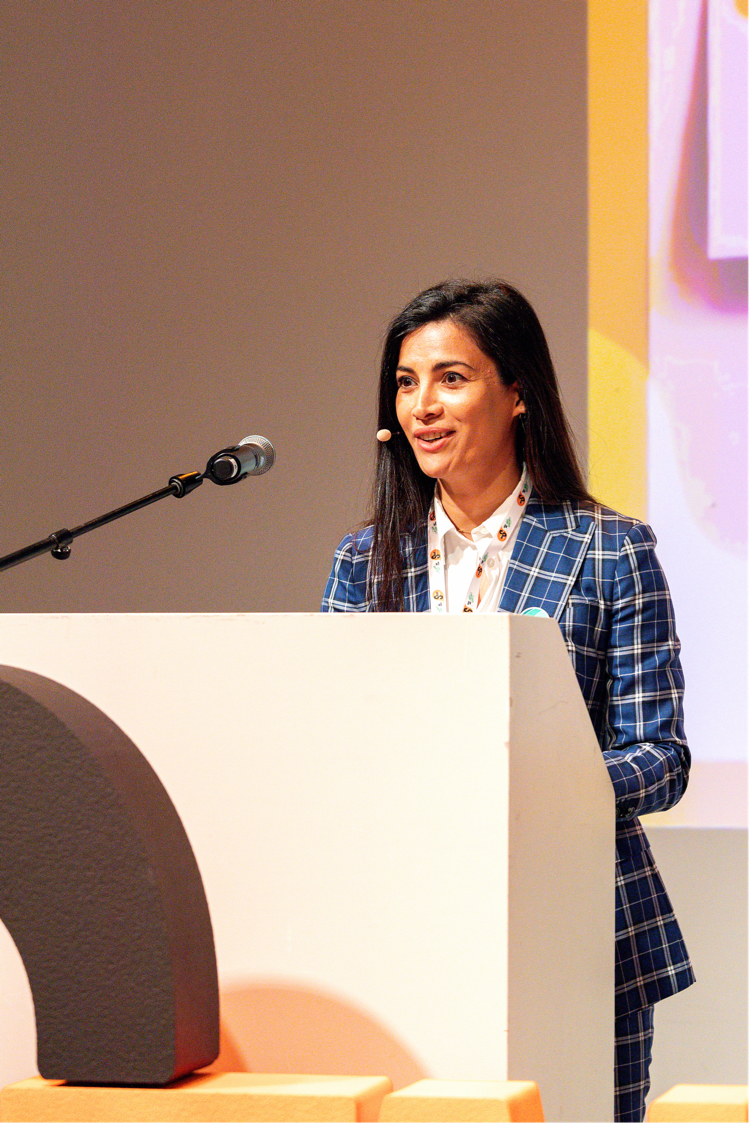 Marwa Zamaray speaking at a podium as an EU Climate Pact Ambassador and Eco Age Executive Director.